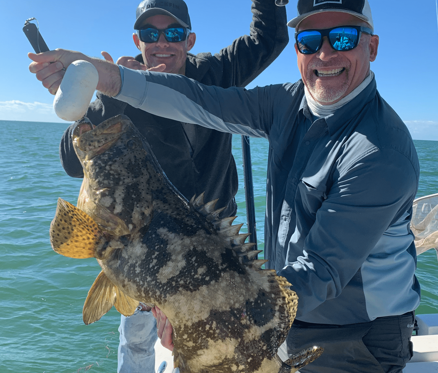 Two men holding a fish caught