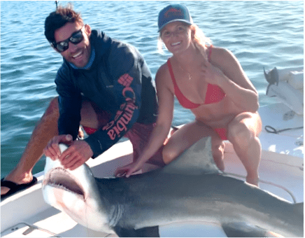 Man and Woman in water with Shark caught