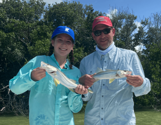 Man and woman posing with fish they caught