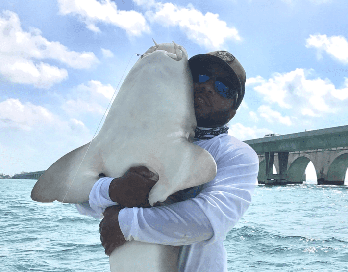 Adult male hugging shark caught